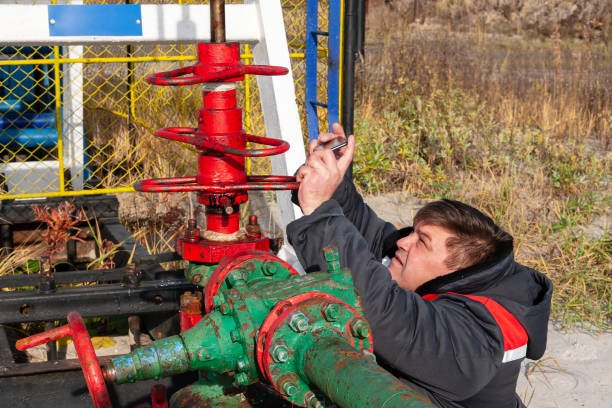 Oil, gas industry. A man near the oil pump. A man photographs on a mobile phone the process of the oil pump close-up.
